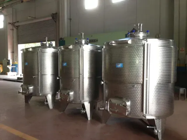 Serbatoi industriali in acciaio inossidabile in un magazzino.