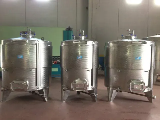 Tre serbatoi in acciaio inox per lo stoccaggio del vino in un magazzino.