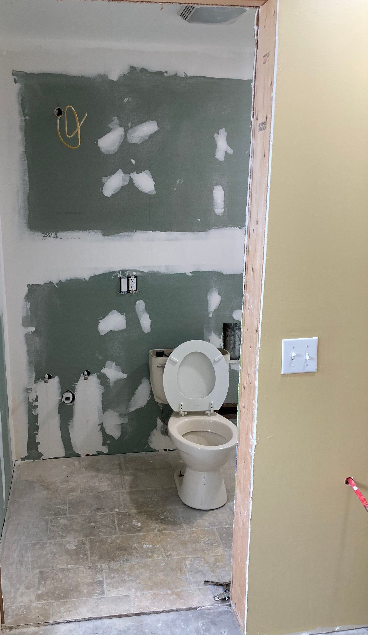 A bathroom with blue tiles and a toilet