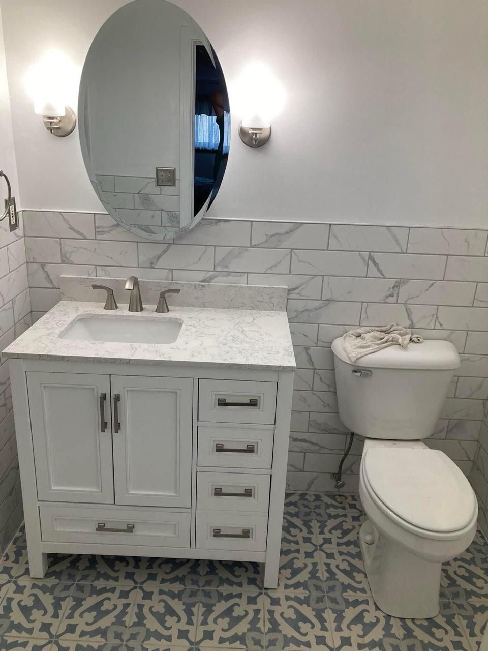 A bathroom with a sink, toilet, and mirror