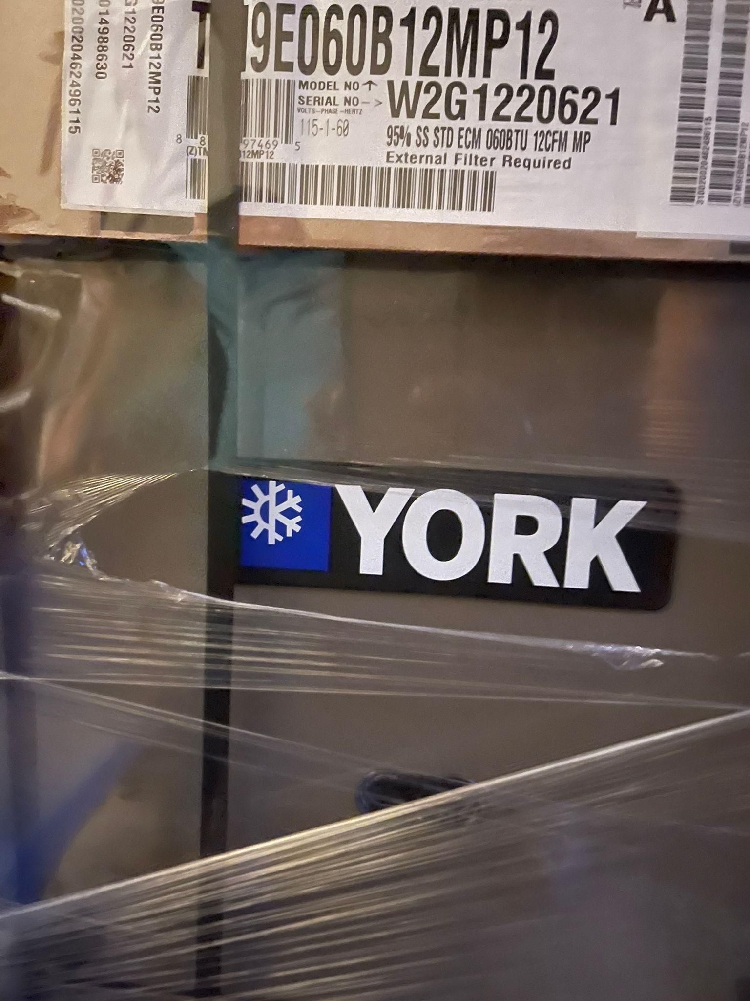 Stacked YORK HVAC units wrapped in plastic, with shipping labels visible.