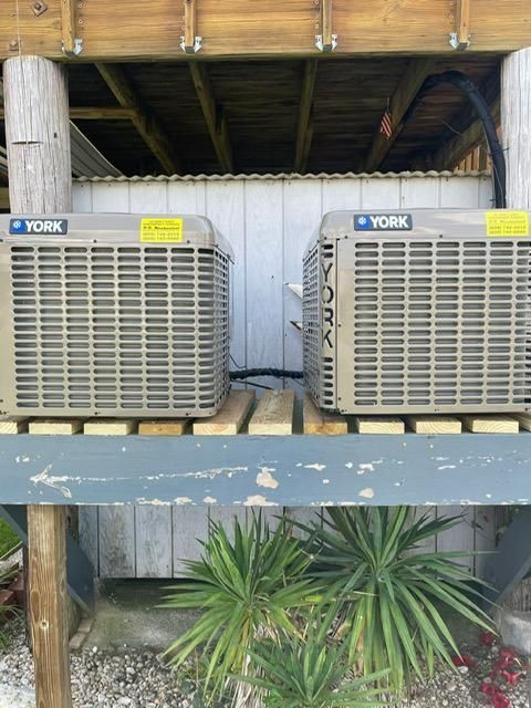 Two YORK air conditioning units mounted on a wooden deck under a covered outdoor structure.