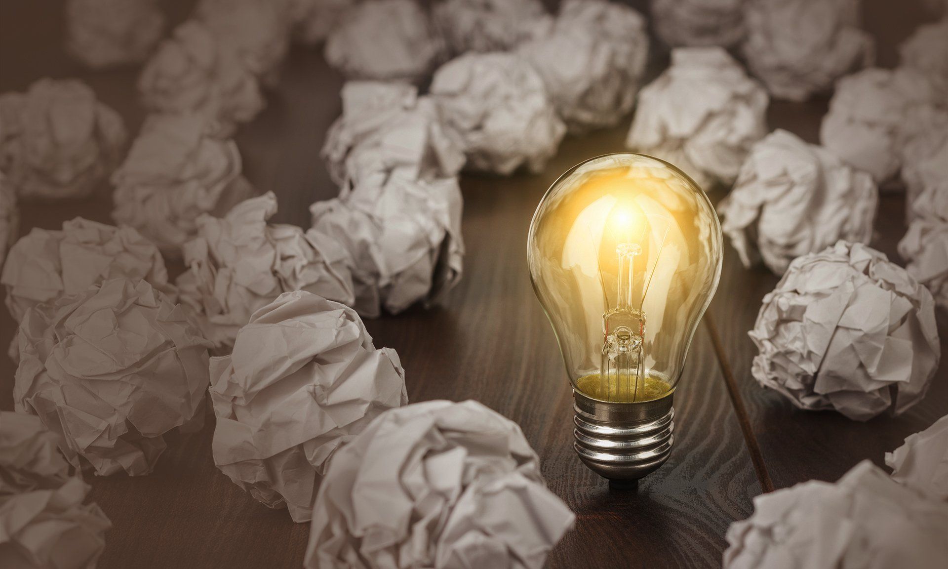 Lightbulb in the middle of crumpled paper balls