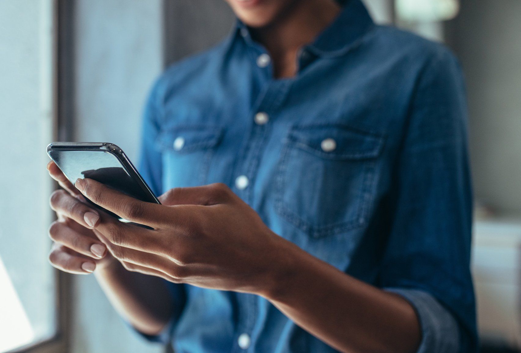 woman holding mobile phone in hands and scrolling through web search