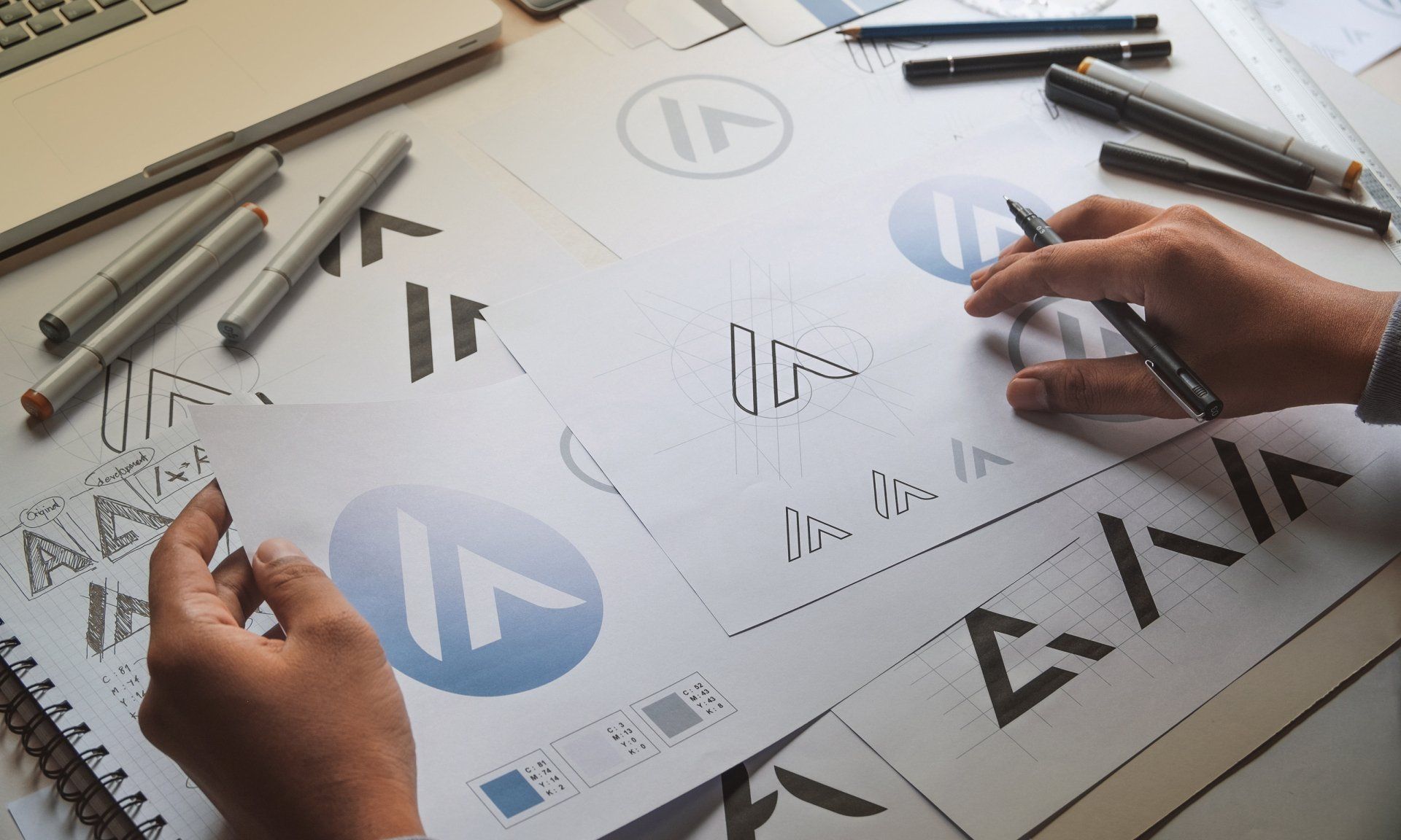 hands on table working on logo design concepts