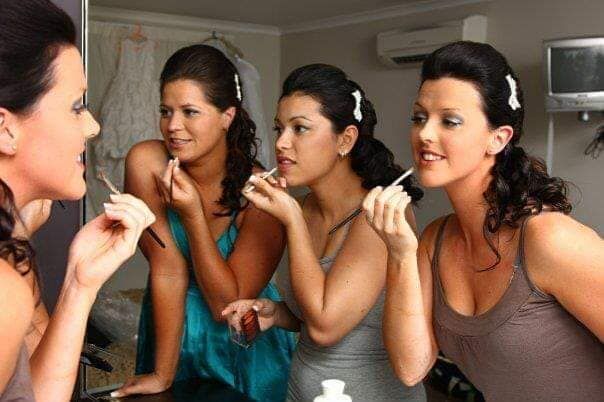 Four Women are Applying Makeup in Front of a Mirror — Bernadette's Beauty Care in Sarina, QLD