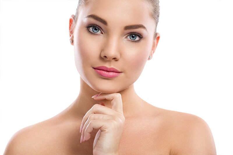 A Close up of a Woman 's face with her Hand on her Chin — Bernadette's Beauty Care in Sarina, QLD