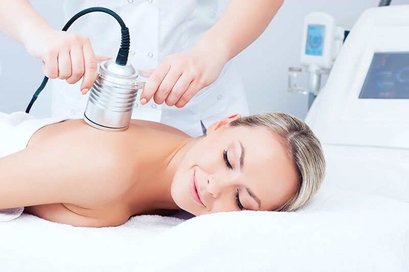 A Woman is Laying on a Bed Getting a Massage — Bernadette's Beauty Care in Sarina, QLD