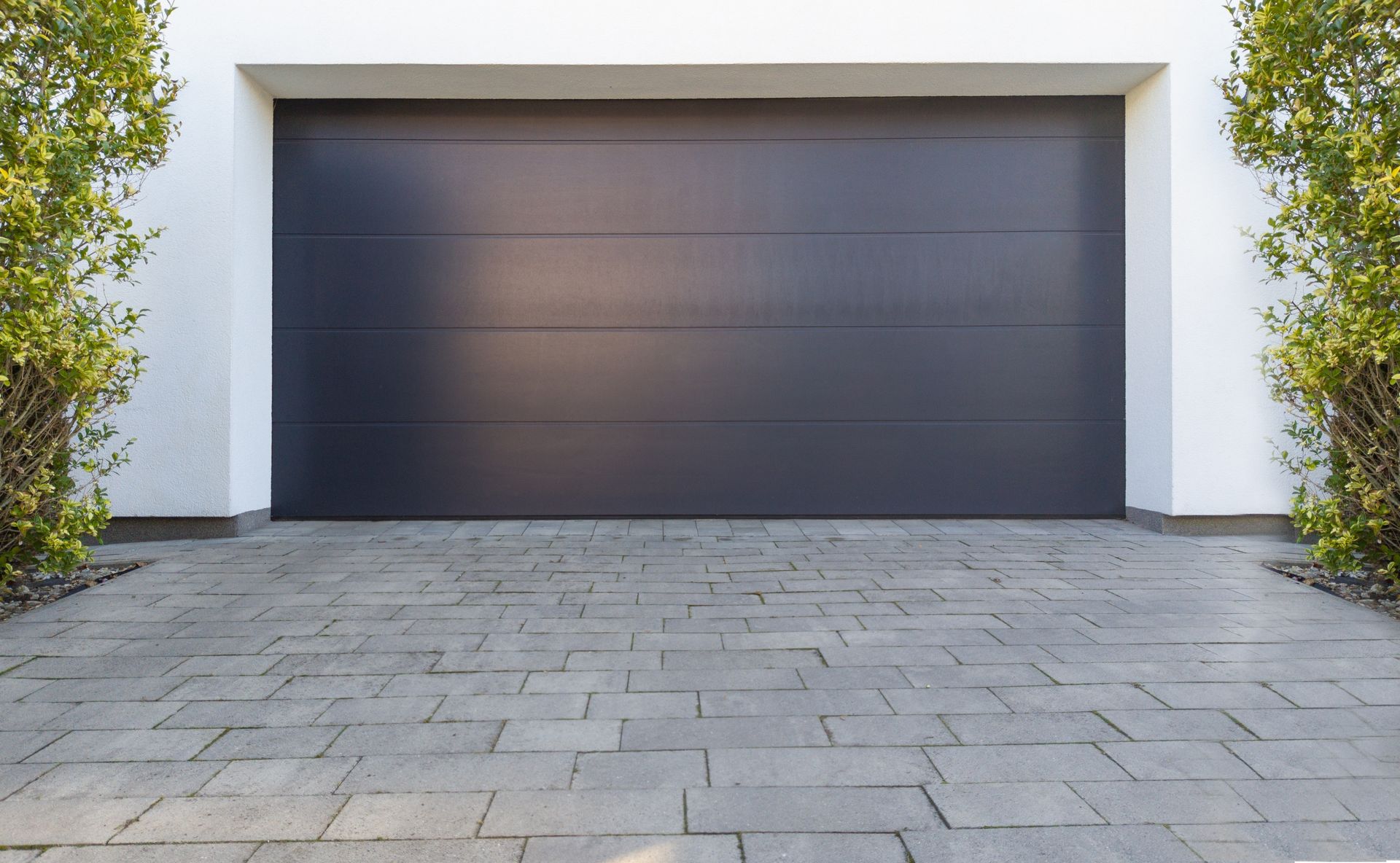 Modern house exterior with a dark garage door and stone driveway