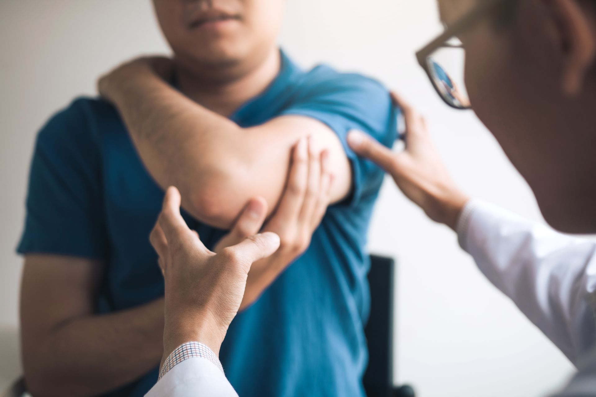A doctor is examining a patient 's elbow in a hospital.