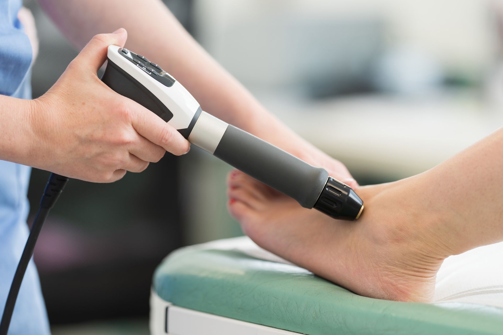 A person is getting a treatment on their ankle with a machine.