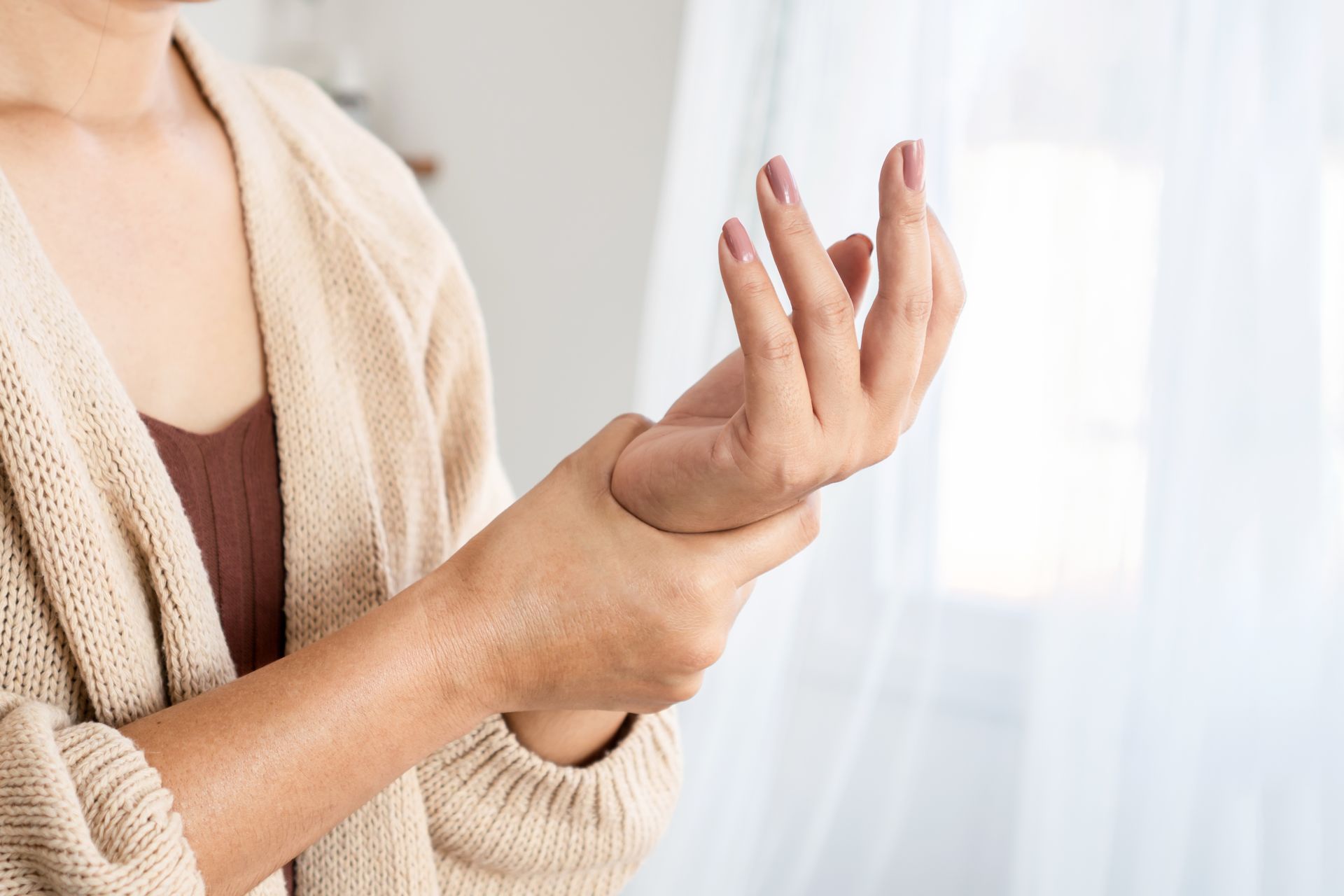 A woman is holding her wrist in pain.