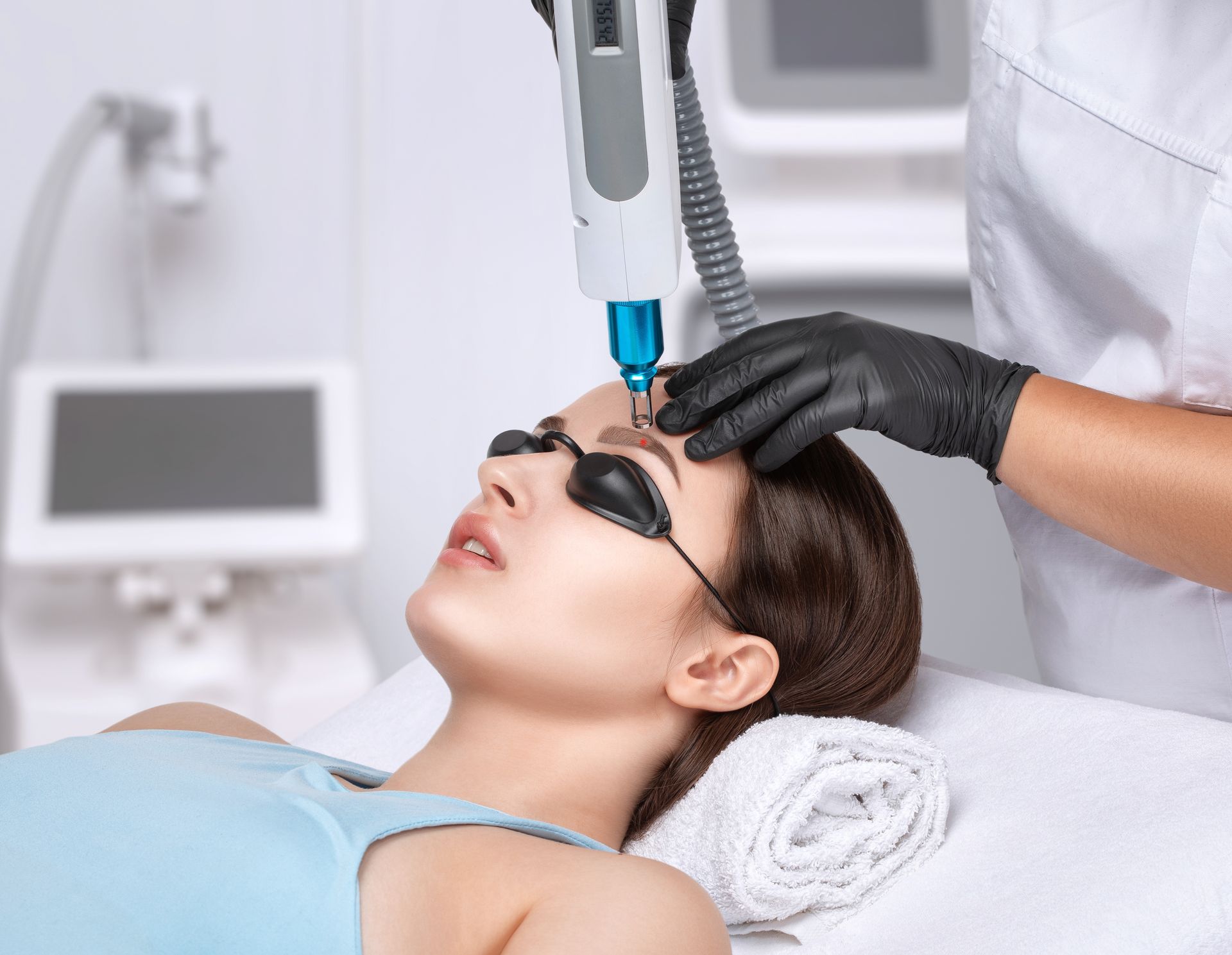 A woman is getting a laser treatment on her face.