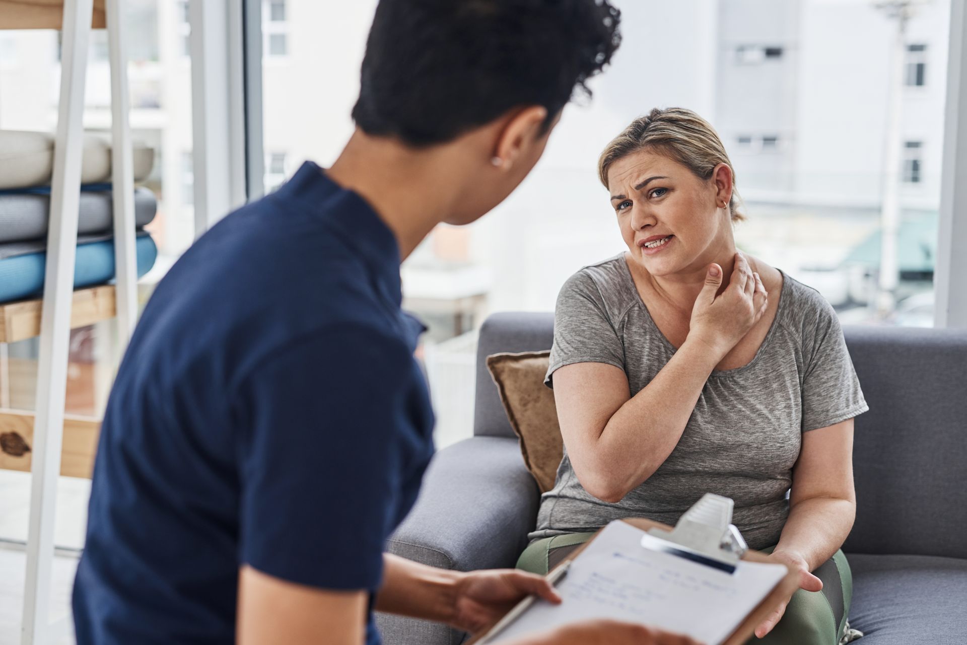 A man is talking to a woman who is sitting on a couch.