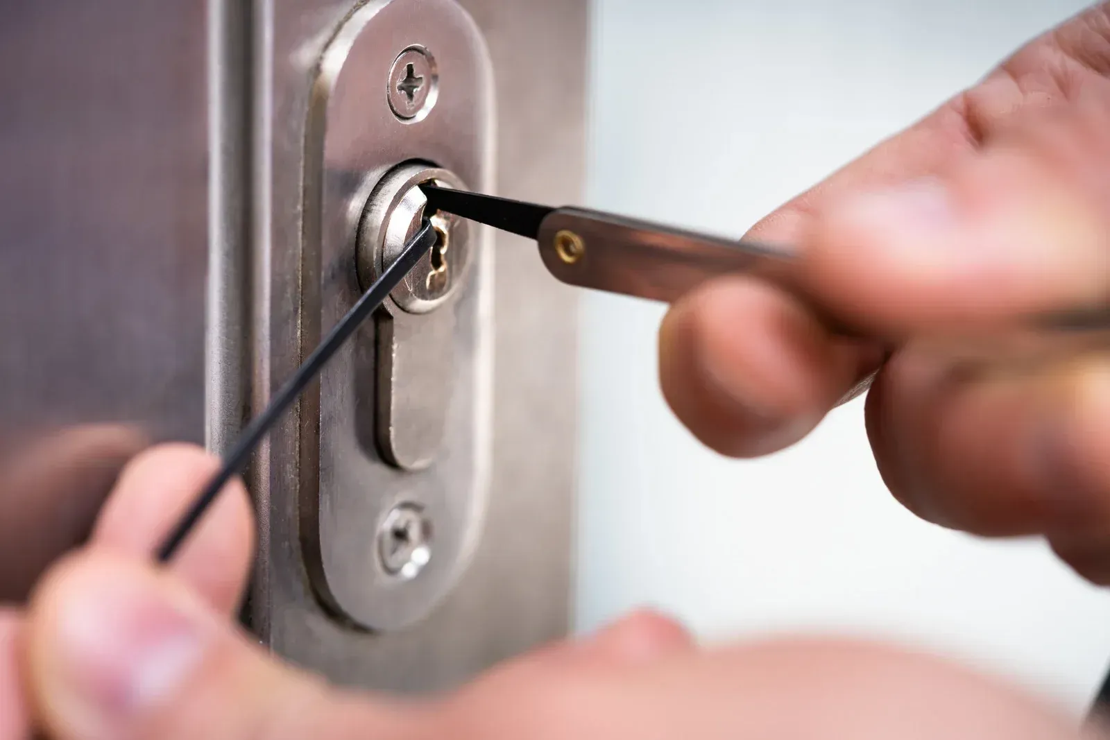 Person installing a black door handle with a yellow power drill.