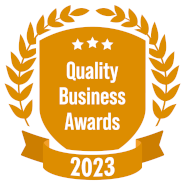 A shield with a laurel wreath and a ribbon that says quality business awards 2023.