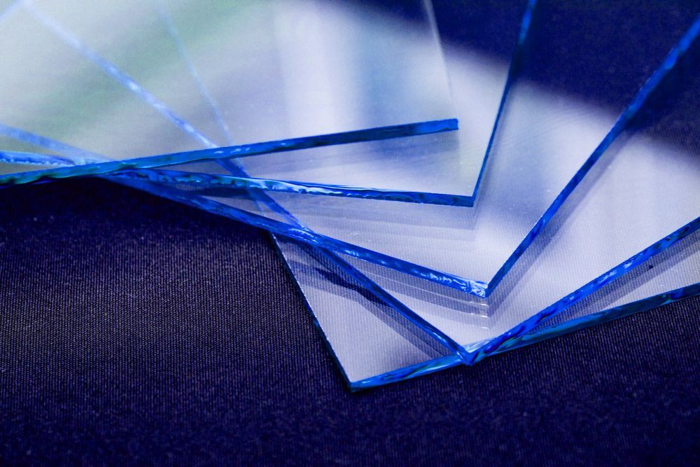 A Stack Of Clear Plastic Sheets On A Blue Surface — Townsville Stained Glass In Cairns, QLD 