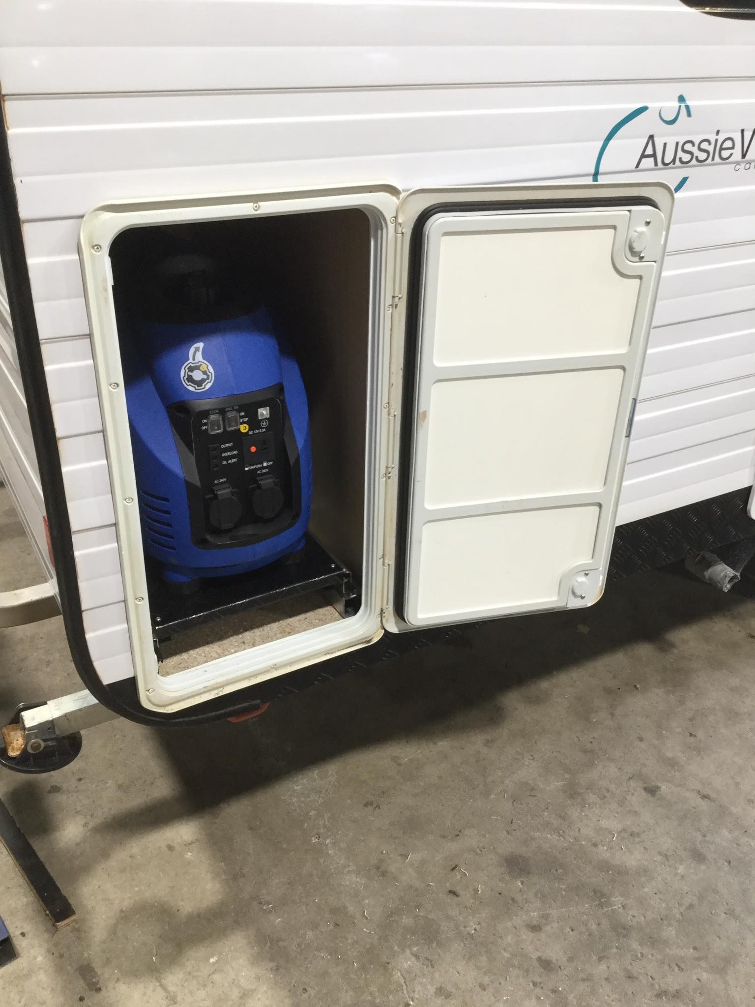 A Blue Generator is Sitting in the Doorway of a Trailer — B & C Caravan Service Pty Ltd In Dubbo, NSW