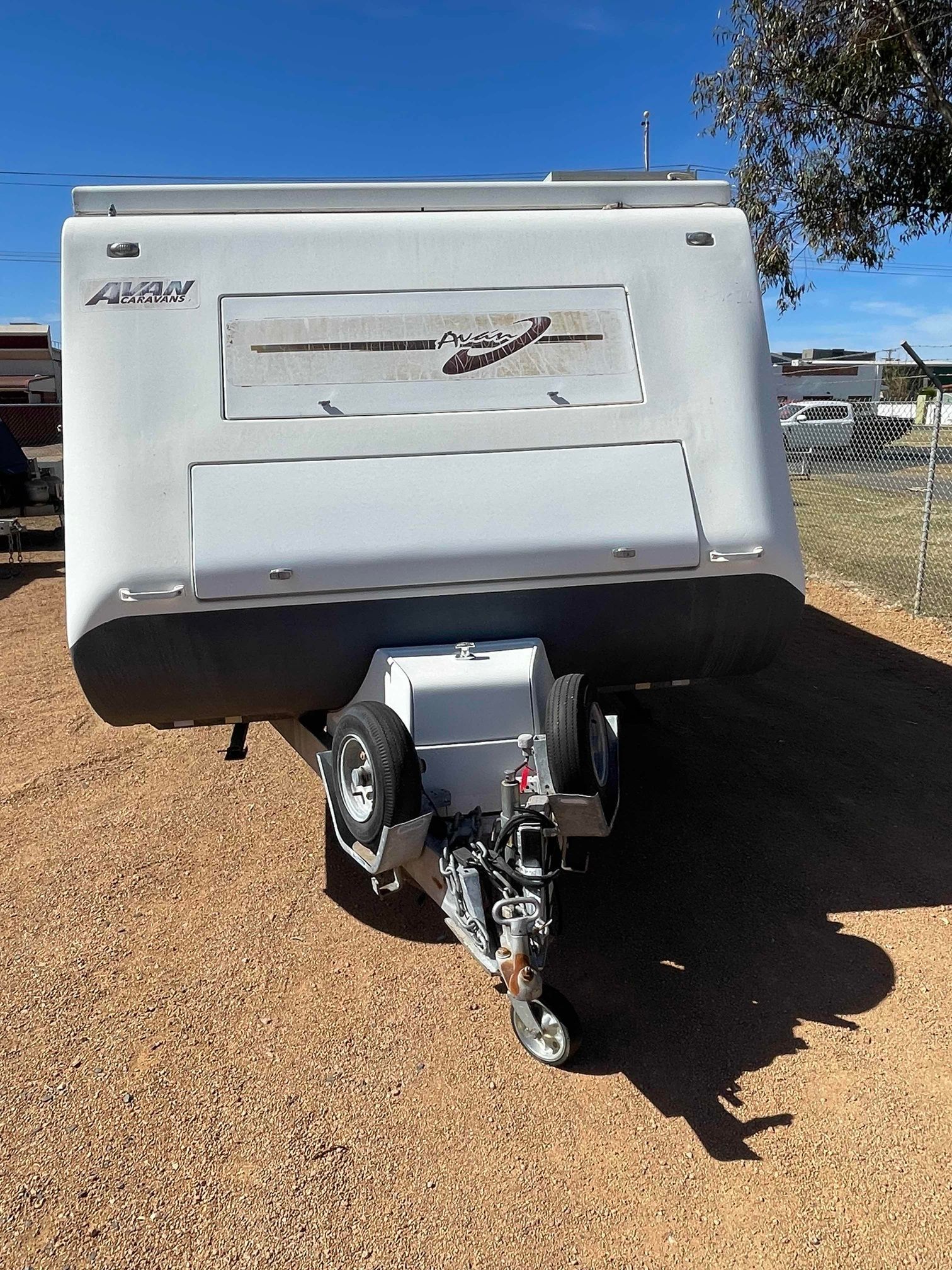 White Travel Trailer Parked on Gravel Under a Blue Sky — B & C Caravan Service Pty Ltd In Dubbo, NSW