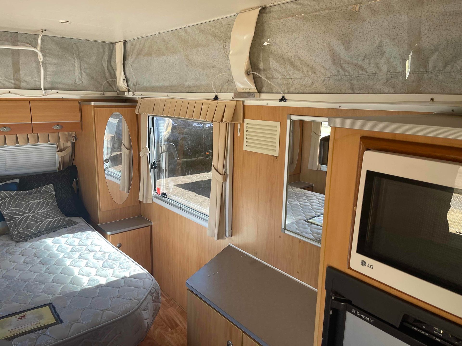 Compact Camper Van Interior With Bed, Wood Paneling — B & C Caravan Service Pty Ltd In Dubbo, NSW