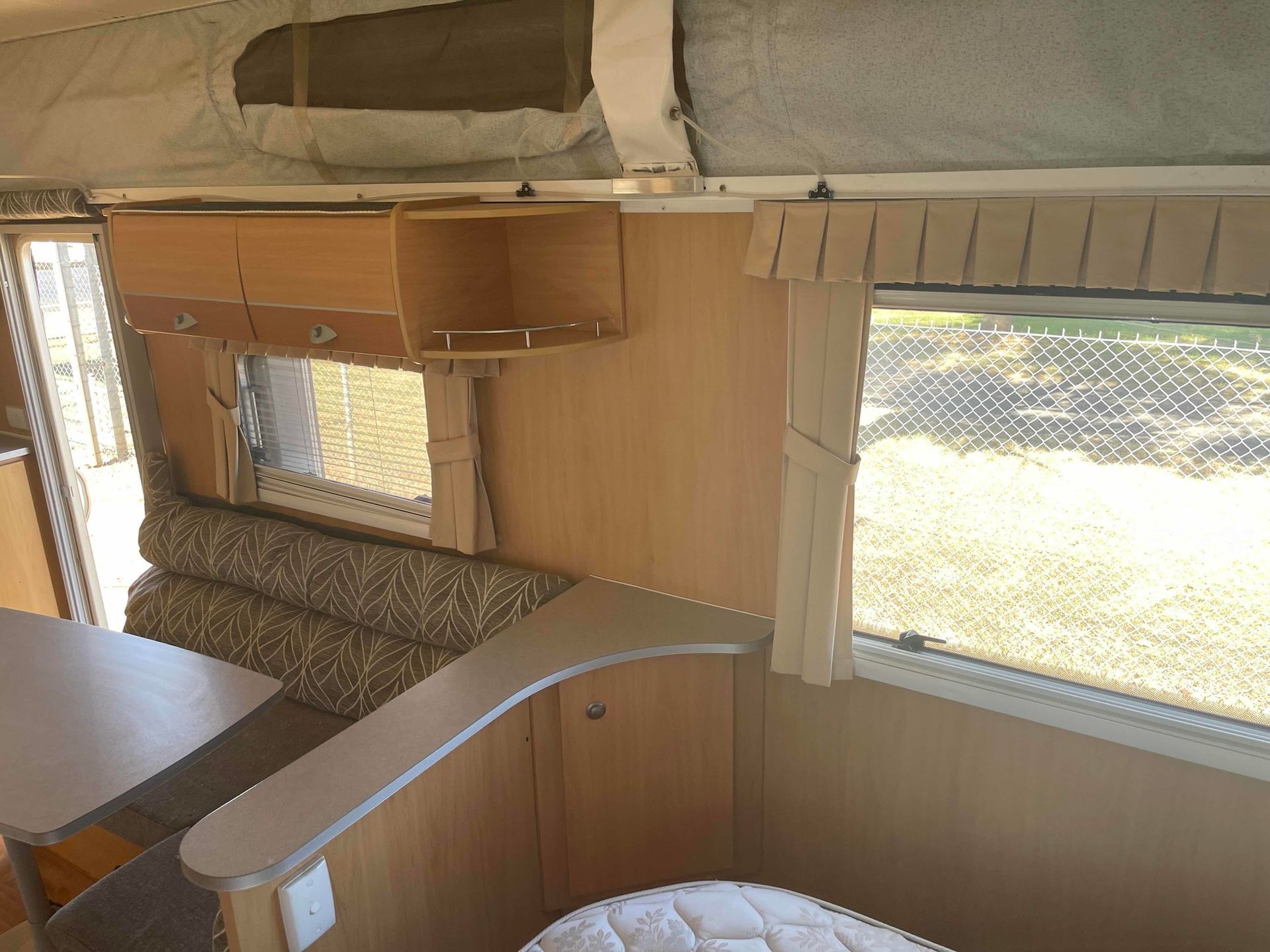 Small Camper Interior With a Curved Bench, Wood Paneling, Table — B & C Caravan Service Pty Ltd In Dubbo, NSW