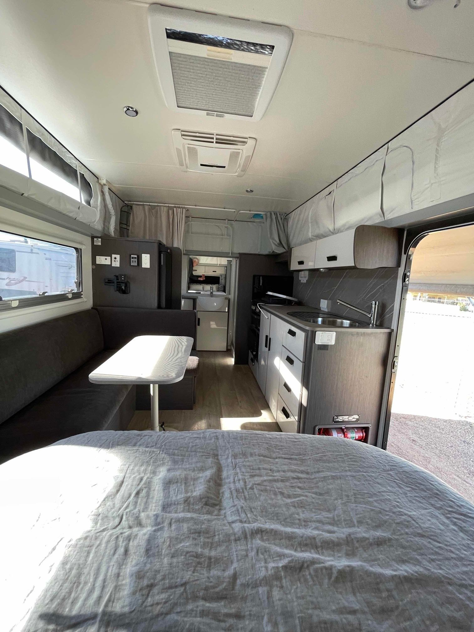 Modern RV interior showcasing a cozy living space with a bed — B & C Caravan Service Pty Ltd In Dubbo, NSW
