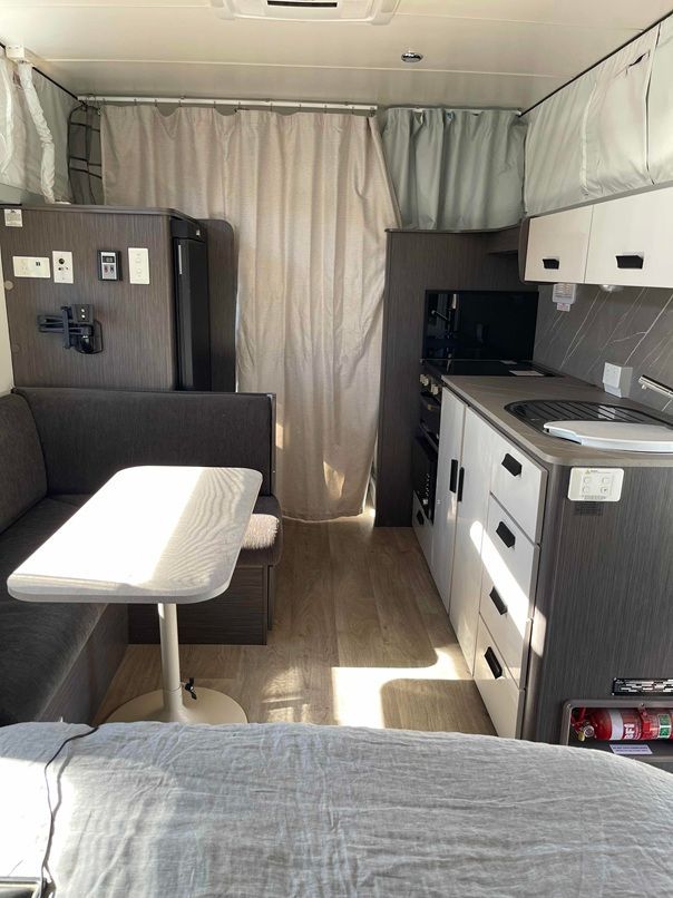 Compact Rv Interior With Bed, Dining Nook, Kitchenette — B & C Caravan Service Pty Ltd In Dubbo, NSW