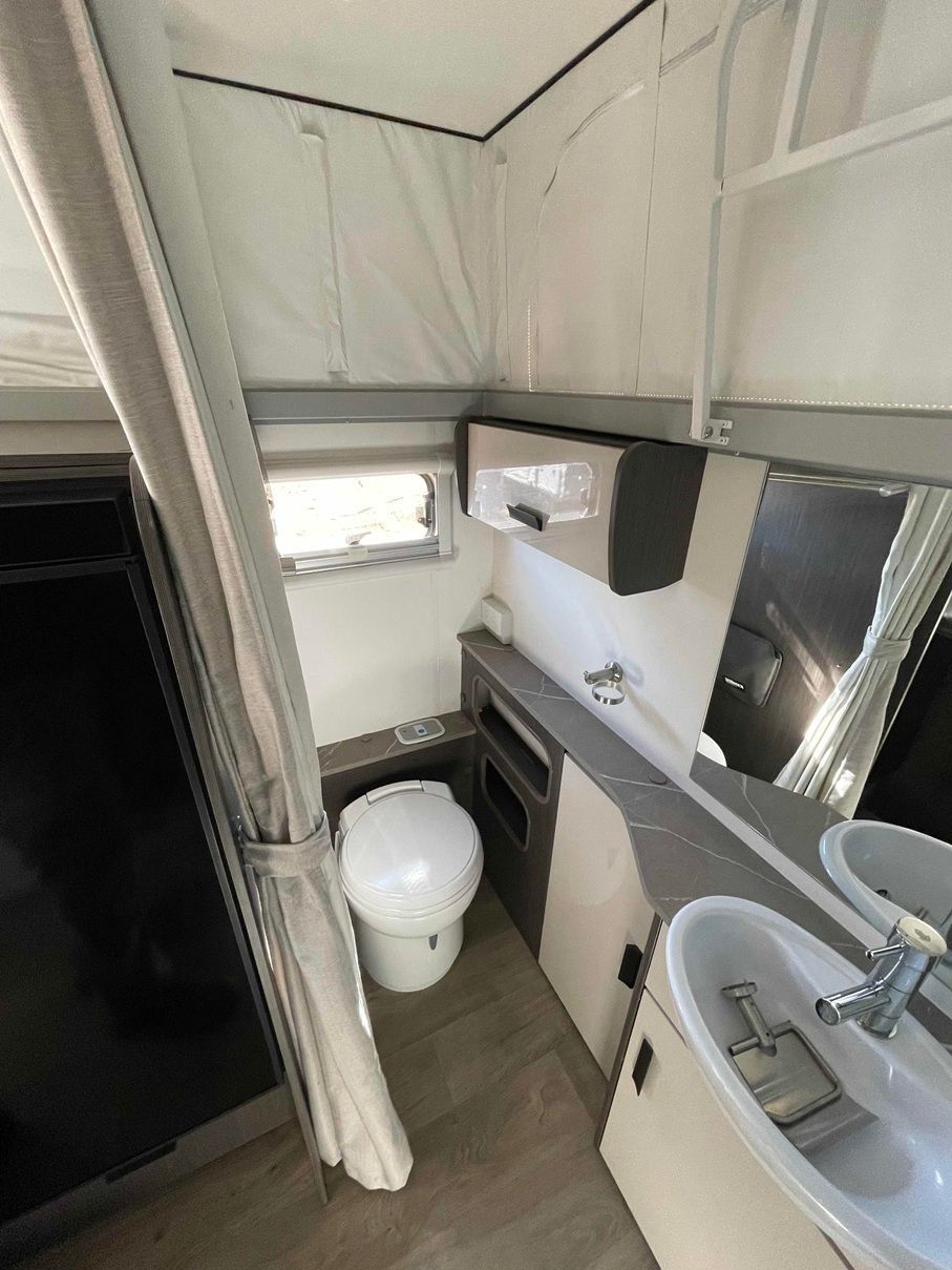 Small Bathroom With Toilet, Sink, Shower Curtain — B & C Caravan Service Pty Ltd In Dubbo, NSW