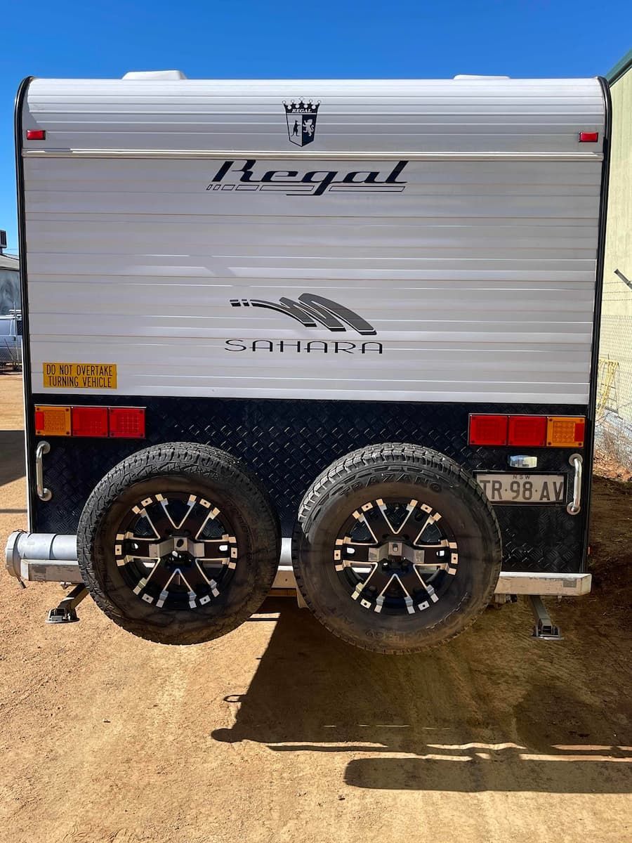 Rear View of a Silver Royal Travel Trailer With Dual Black Wheels Parked — B & C Caravan Service Pty Ltd In Dubbo, NSW