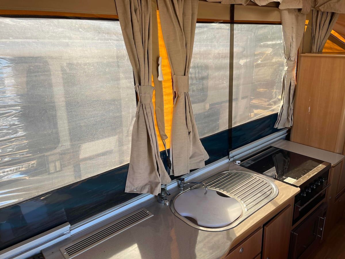Small Kitchen Counter With Sink, Stove, and Window Covered — B & C Caravan Service Pty Ltd In Dubbo, NSW