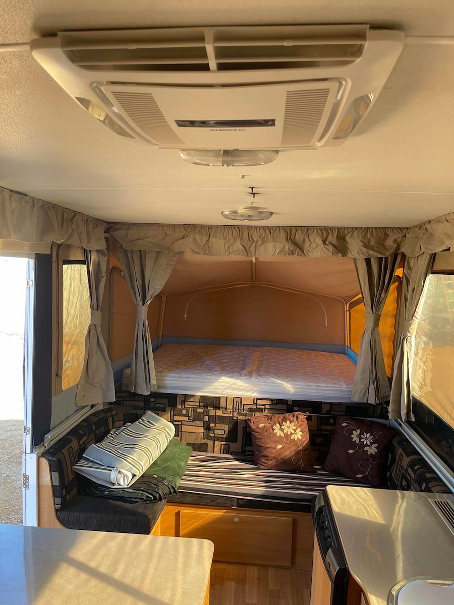 Inside a Camper Van, a Cozy Bed and Shelves — B & C Caravan Service Pty Ltd In Dubbo, NSW