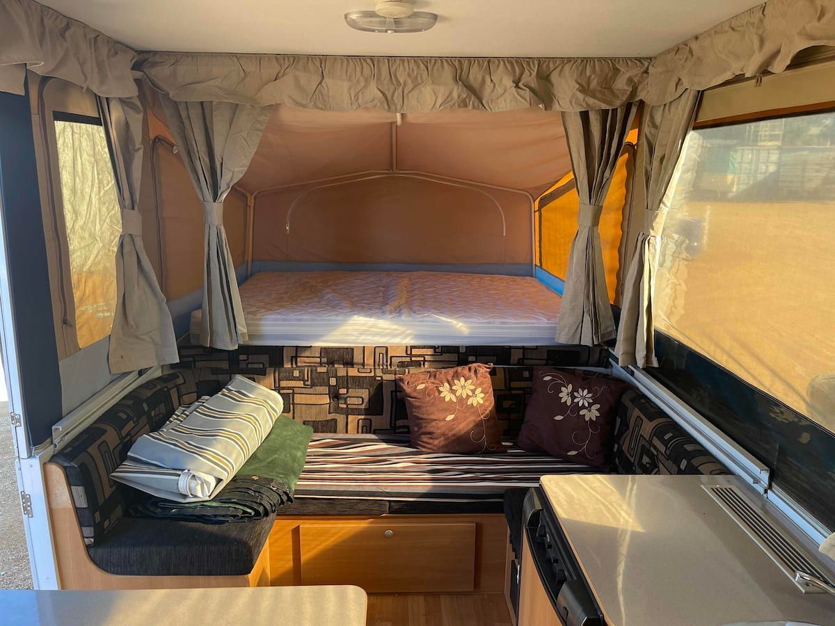Camper Interior With a Bed, Cushioned Bench — B & C Caravan Service Pty Ltd In Dubbo, NSW
