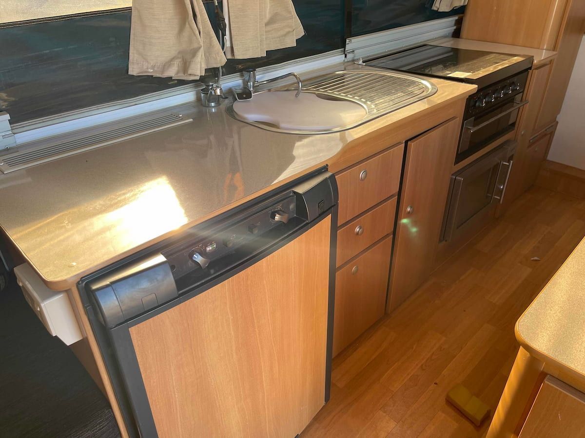 Small Kitchen With Wooden Cabinets, Sink, Refrigerator — B & C Caravan Service Pty Ltd In Dubbo, NSW