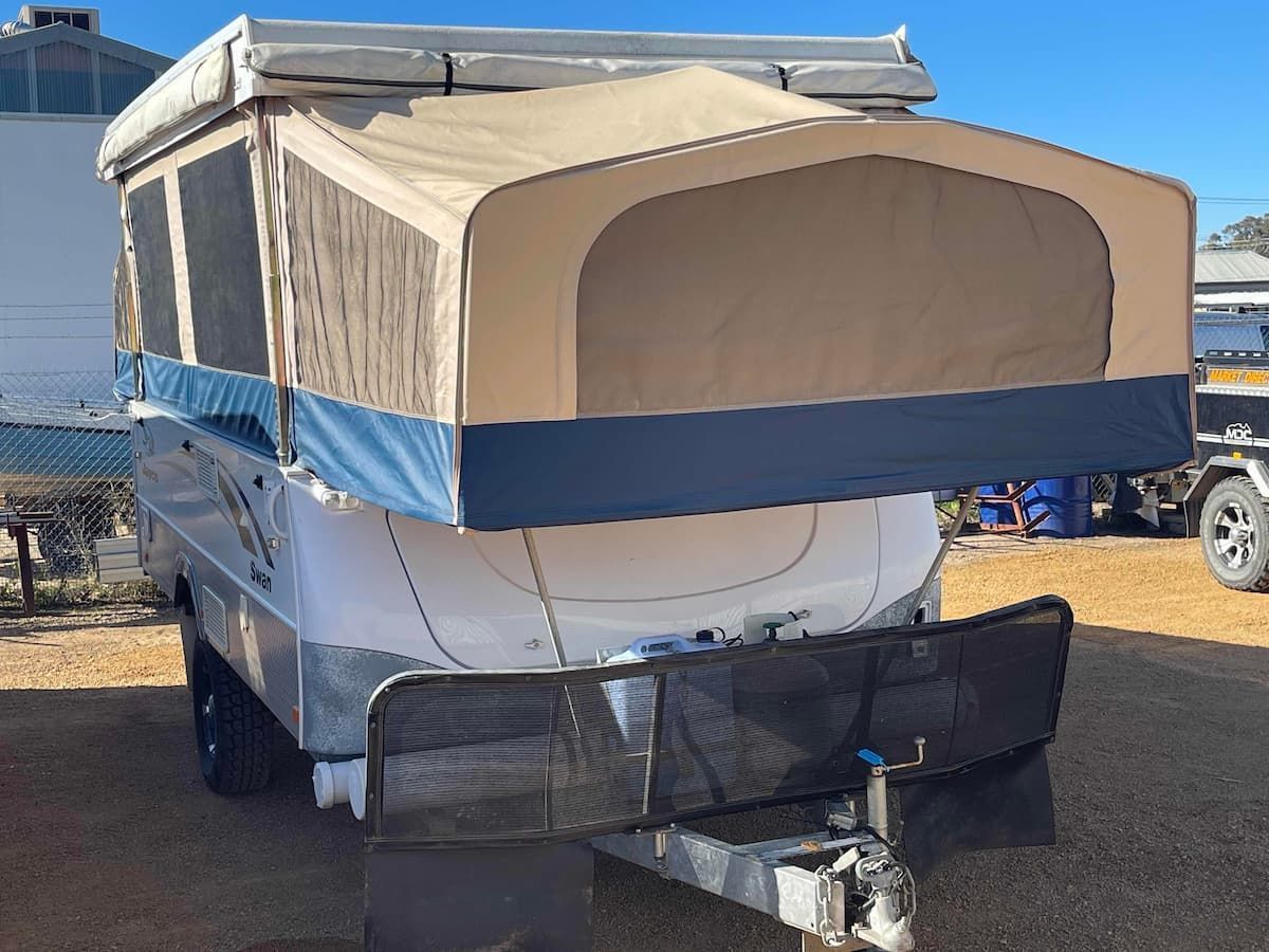 Tan-and-blue Pop-up Camper Trailer With a Front Cargo Rack Parked — B & C Caravan Service Pty Ltd In Dubbo, NSW
