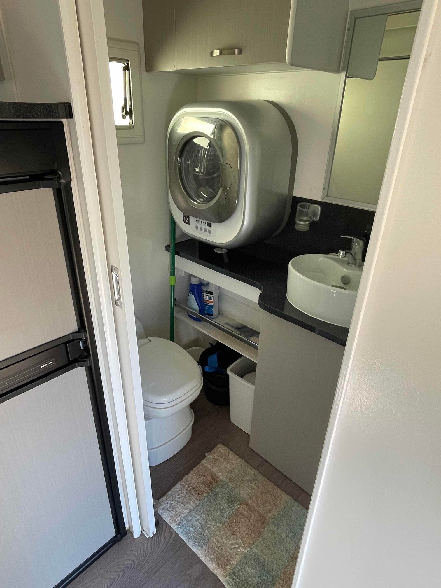 Compact Bathroom with Toilet, Sink, and Wall Mounted Towel Warmer in A Narrow, Modern Space — B & C Caravan Service Pty Ltd In Dubbo, NSW