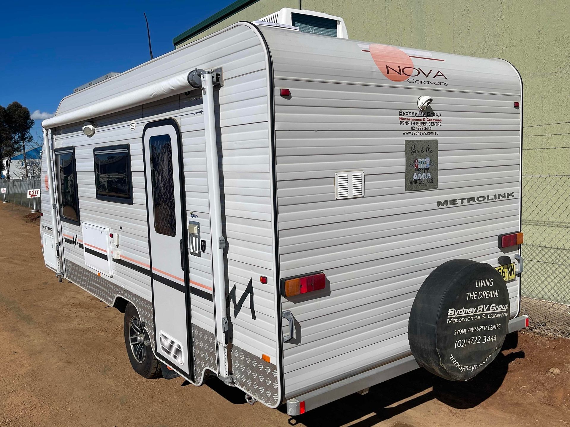 White Travel Trailer Parked on A Dirt Lot Under a Blue Sky, with Windows and A Rear Spare Tire — B & C Caravan Service Pty Ltd In Dubbo, NSW