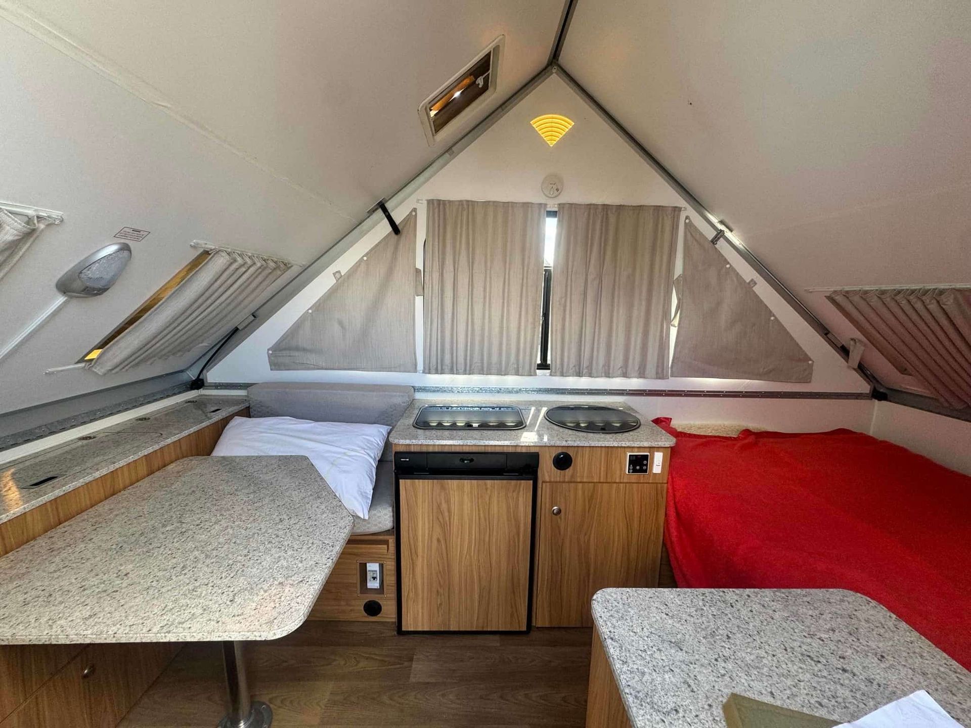 The Inside of a Camper With a Table and a Bed — B & C Caravan Service Pty Ltd In Dubbo, NSW