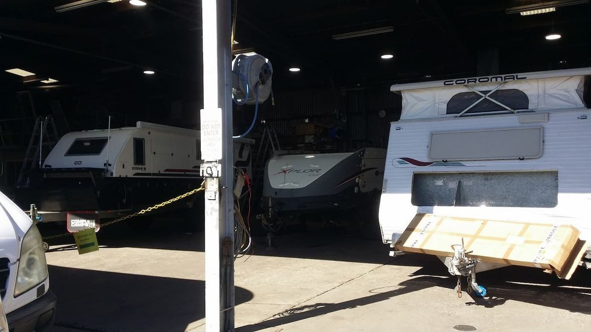 A Row of Caravans Are Parked in a Garage — B & C Caravan Service Pty Ltd In Dubbo, NSW