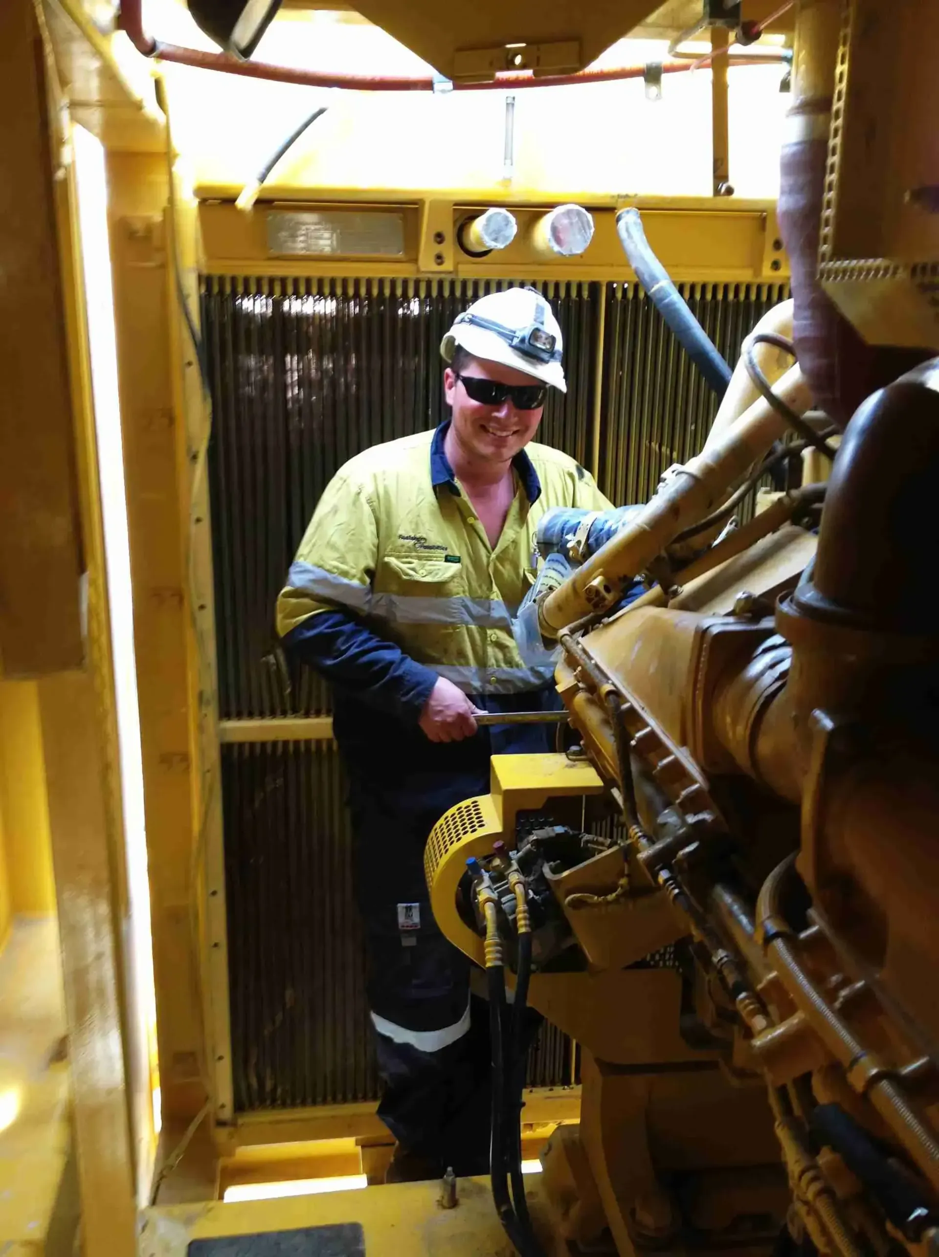 A man working on PC3000 mining excavator and removing a radiator on remote Queensland mine site