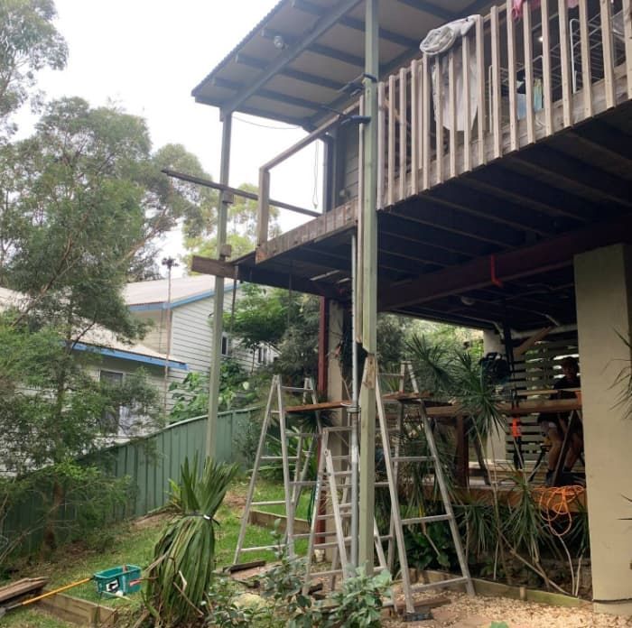 A House With A Wooden Deck And Stairs Leading Up To It — Penman Projects In Salamander Bay, NSW