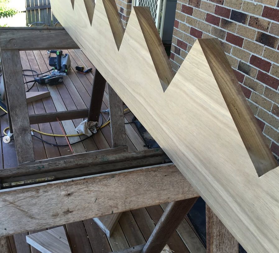 A Wooden Staircase Is Being Built In Front Of A Brick Building — Penman Projects In Salamander Bay, NSW