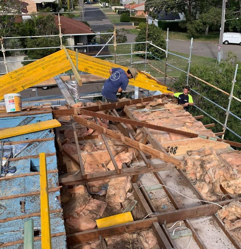 A Man Is Working On The Roof Of A Building — Penman Projects In Nelson Bay, NSW