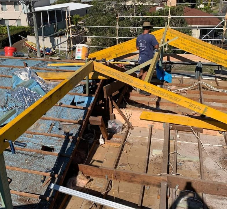 A Man Is Standing On Top Of A Wooden Structure — Penman Projects In Shoal Bay, NSW