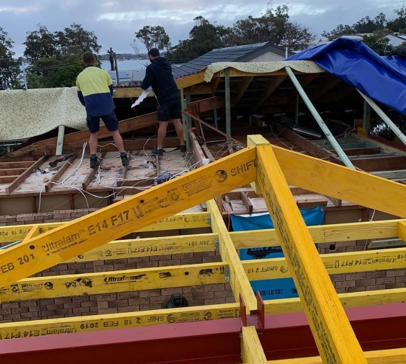 Two Men Are Working On The Roof Of A Building — Penman Projects In Anna Bay, NSW