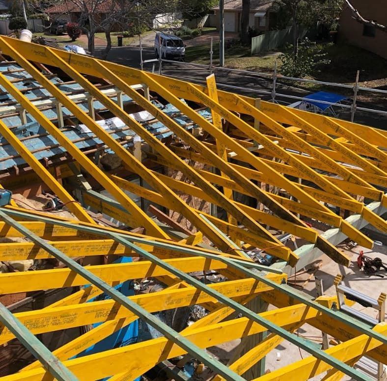 A Roof That Is Being Built With Yellow Beams — Penman Projects In Salamander Bay, NSW