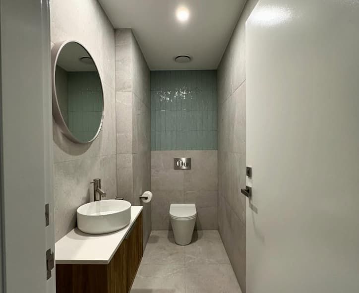 A Bathroom With A Sink , Toilet And Mirror — Penman Projects In Shoal Bay, NSW