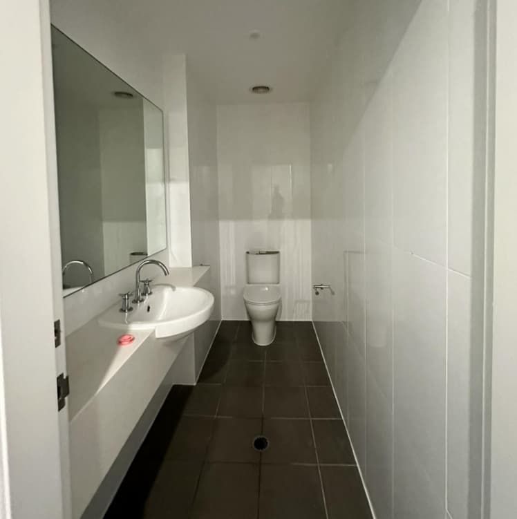 A Bathroom With A Toilet Sink And Mirror — Penman Projects In Anna Bay, NSW