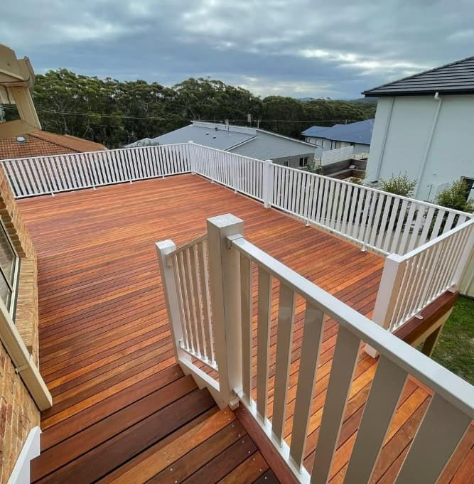 A Wooden Deck With A White Railing And Stairs Leading Up To It — Penman Projects In Anna Bay, NSW