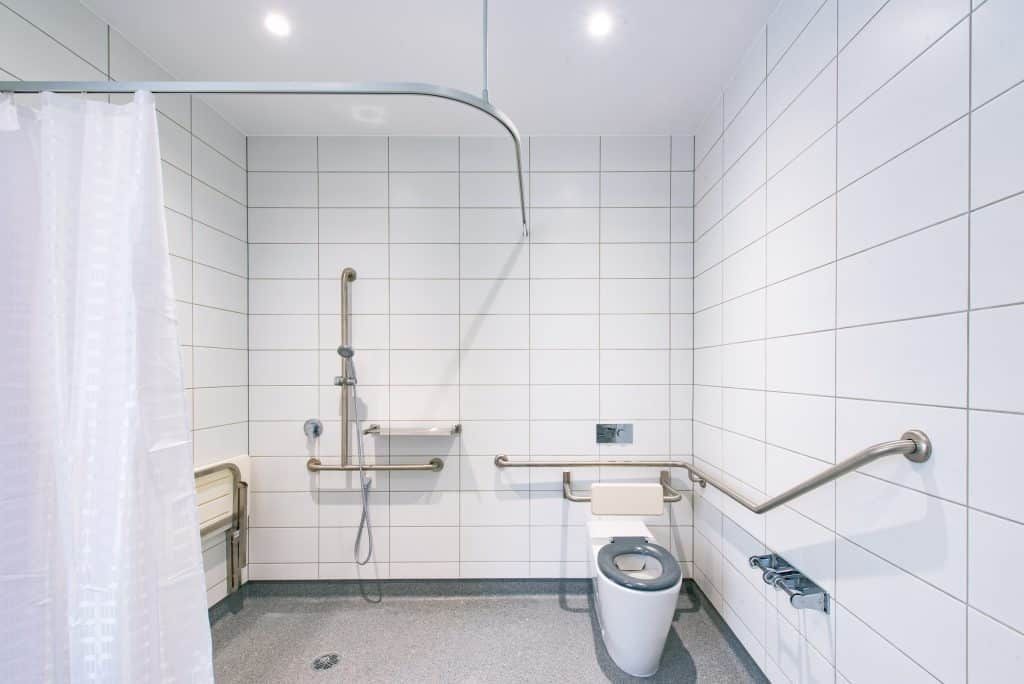 A Bathroom With A Toilet , Shower And Handrails — Frank Plumbing In Delacombe, VIC