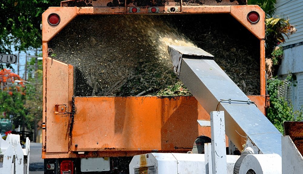 A Tree Chipper is Cutting Down Trees on a City Street — Tallow Tree Services Pty Ltd in Casino, NSW